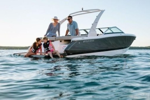 a man riding on the back of a boat in the water